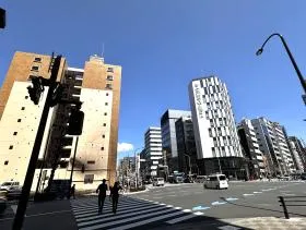 出入口の前にある横断歩道で反対側に渡り、少し左に進めば当ビル着