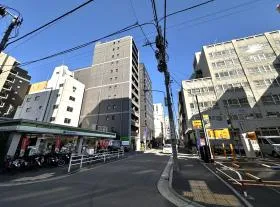 ファミリーマート、駐車場の間にある道を直進していけば当ビル着